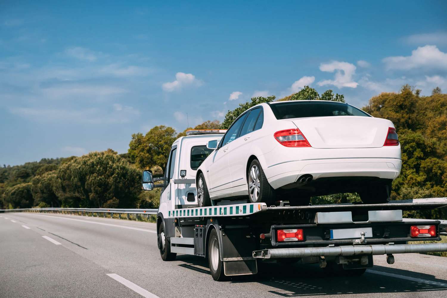 Careful Towing rollback flatbed tow truck loading a vehicle